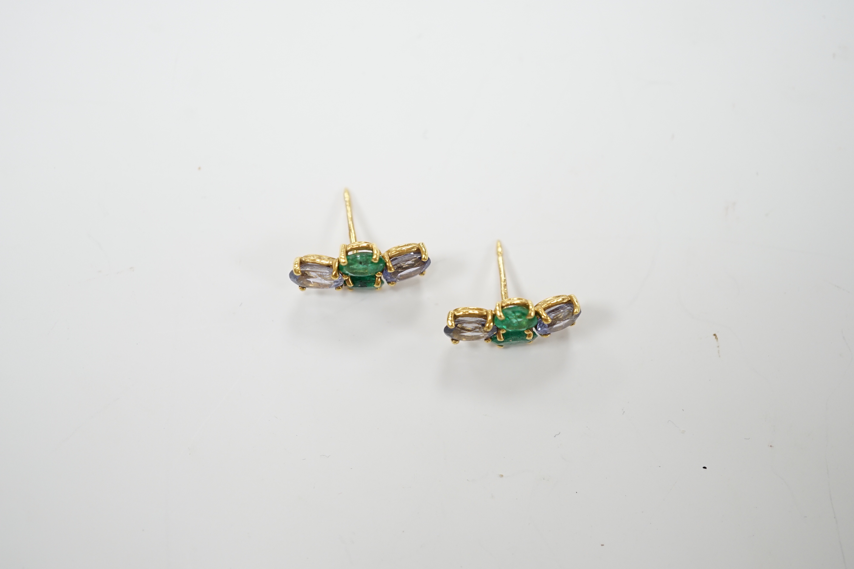 A modern pair of 18ct gold, two stone emerald and two stone sapphire set ear studs, 15mm by 7mm, gross weight 3 grams.